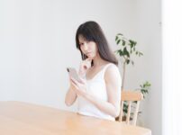 携帯を持ち悩む日本人女性