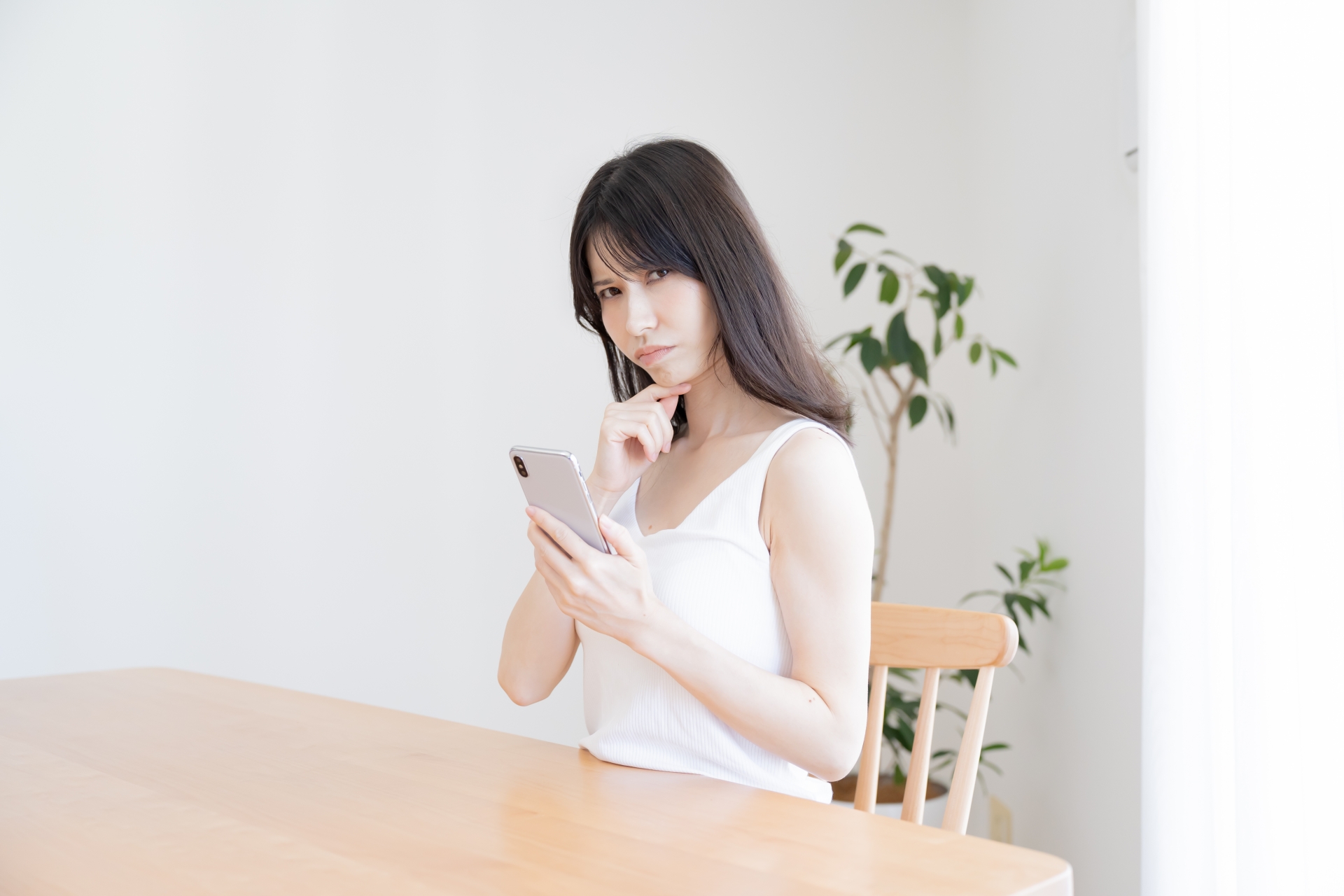 携帯を持ち悩む日本人女性