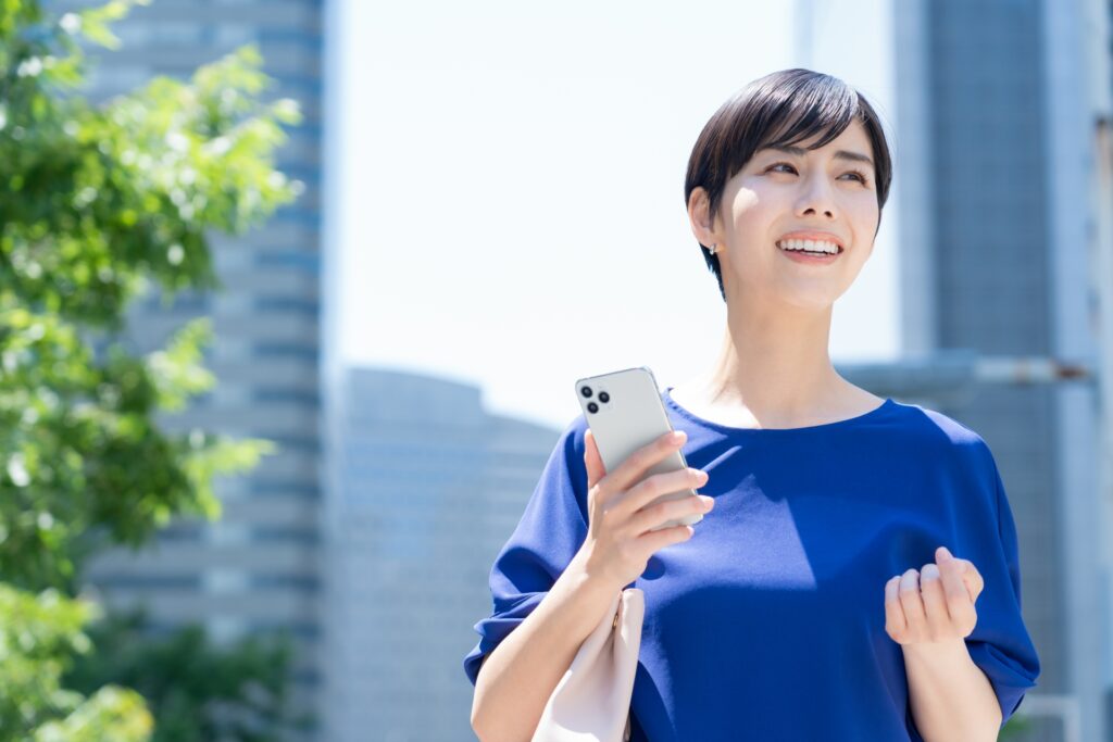 スマートフォンでポイ活アプリを使う女性